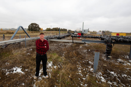 Daryl Bennett poses near oil and gas infrastructure near Taber, Alta