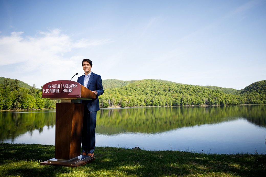 Justin Trudeau standing out a podium next to a lake