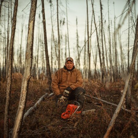 Robert Spence sits in a forest