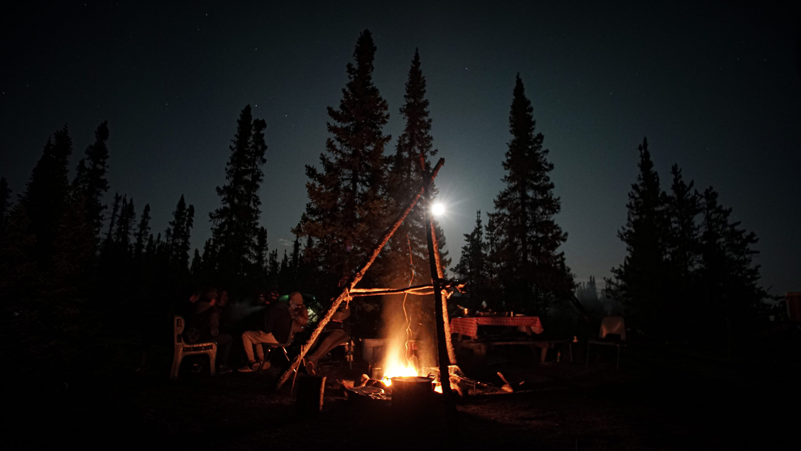 campfire at night with people sitting around it