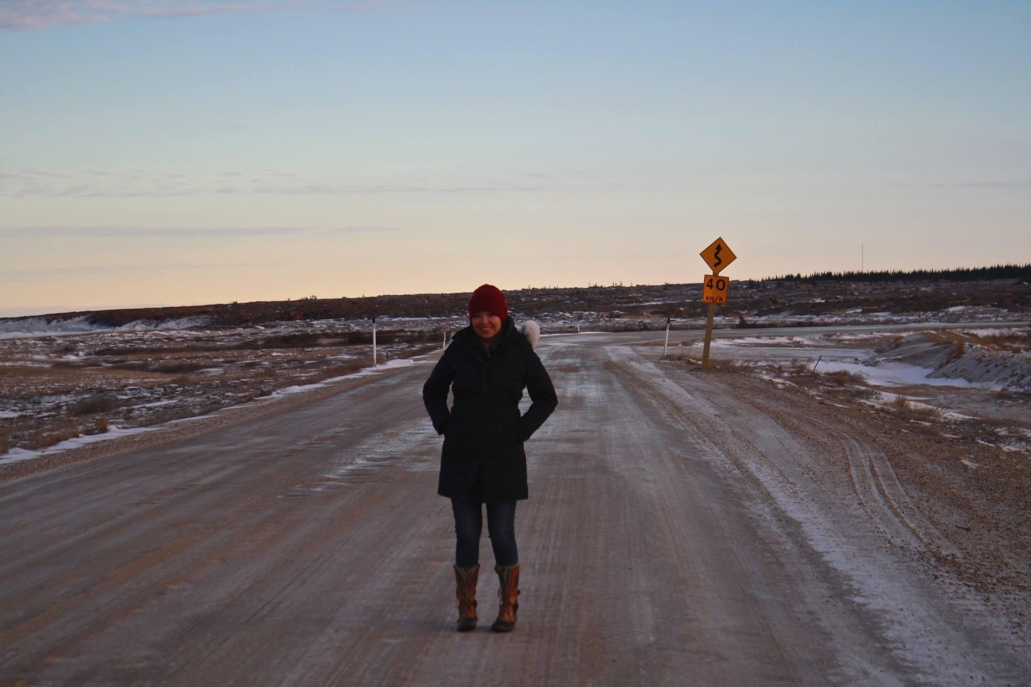 Stephanie Thorassie standing on an empty dirt road in Churchill 