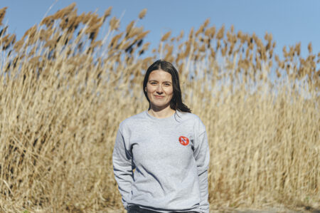 Eva Voinigescu standing in front of tall grass