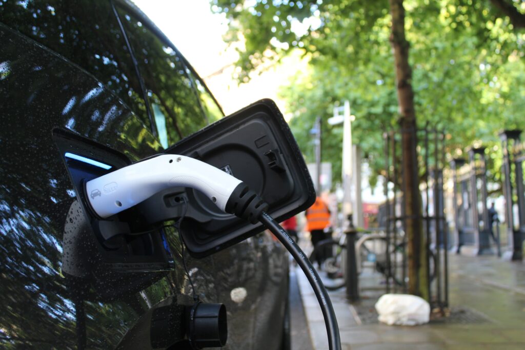electric car charging on a street with trees