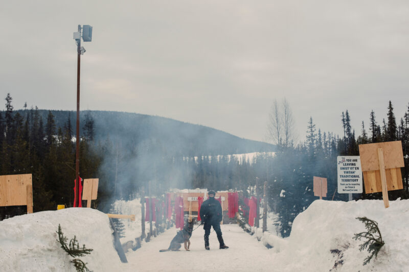 RCMP officer standing alone with dog at Unist'ot'en Healing Centre