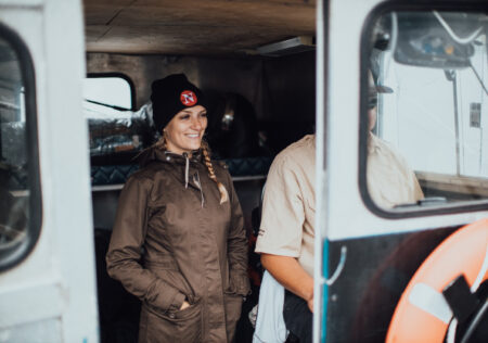 Emma Gilchrist aboard a Heiltsuk Coastal Guardian Watchmen vessel wearing a narwhal toque