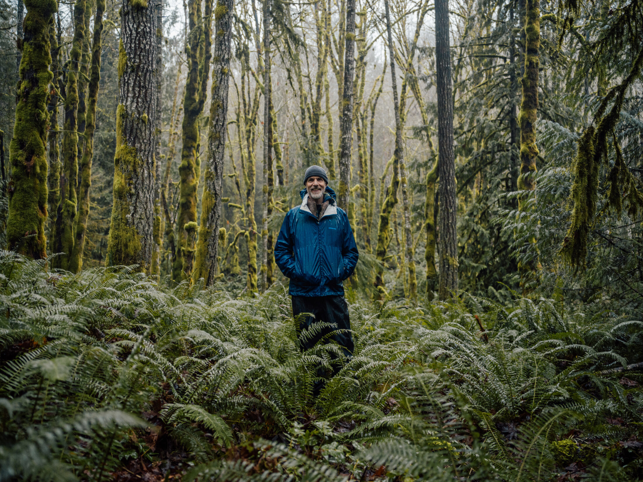 Tom Rutherford stands in a lush green forest