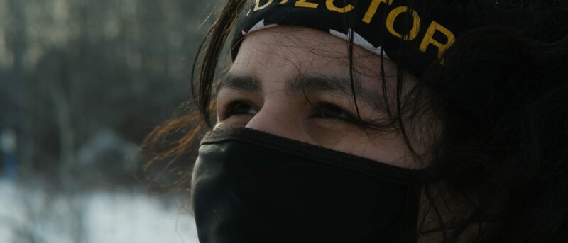 Taysha Martineau wearing a mask and bandanna saying "protector"