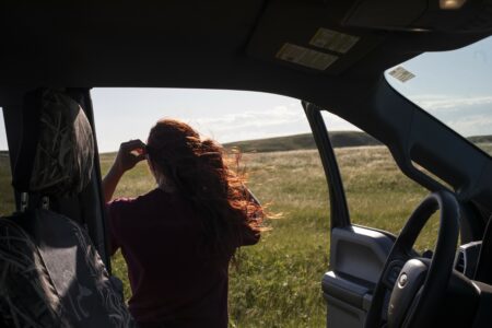 Mickenzie Plemel-Stronks looks out onto grassland from a car