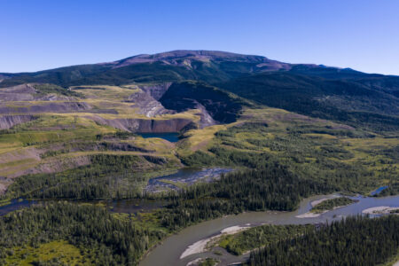 Open pit coal mine in a hill with a river in the foreground