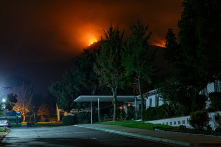residential street with wildfire in background