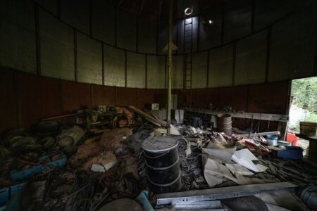An abandoned silo at the staging area is filled with trash