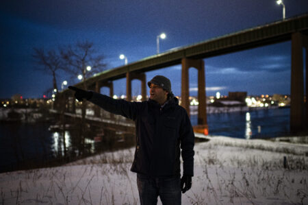Selva Rasaiah, a former auditor of Algoma Steel, points across from St. Mary's river to emissions emanating from the Algoma steel plant, in Sault Ste., Marie, Ont. Photo: Christopher Katsarov Luna / The Narwhal