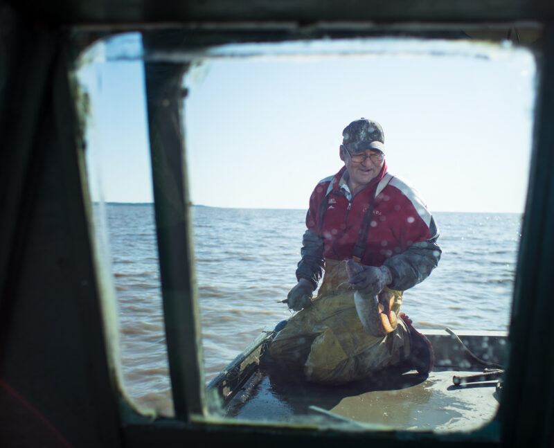 a man stands in a boat holding a fishing net