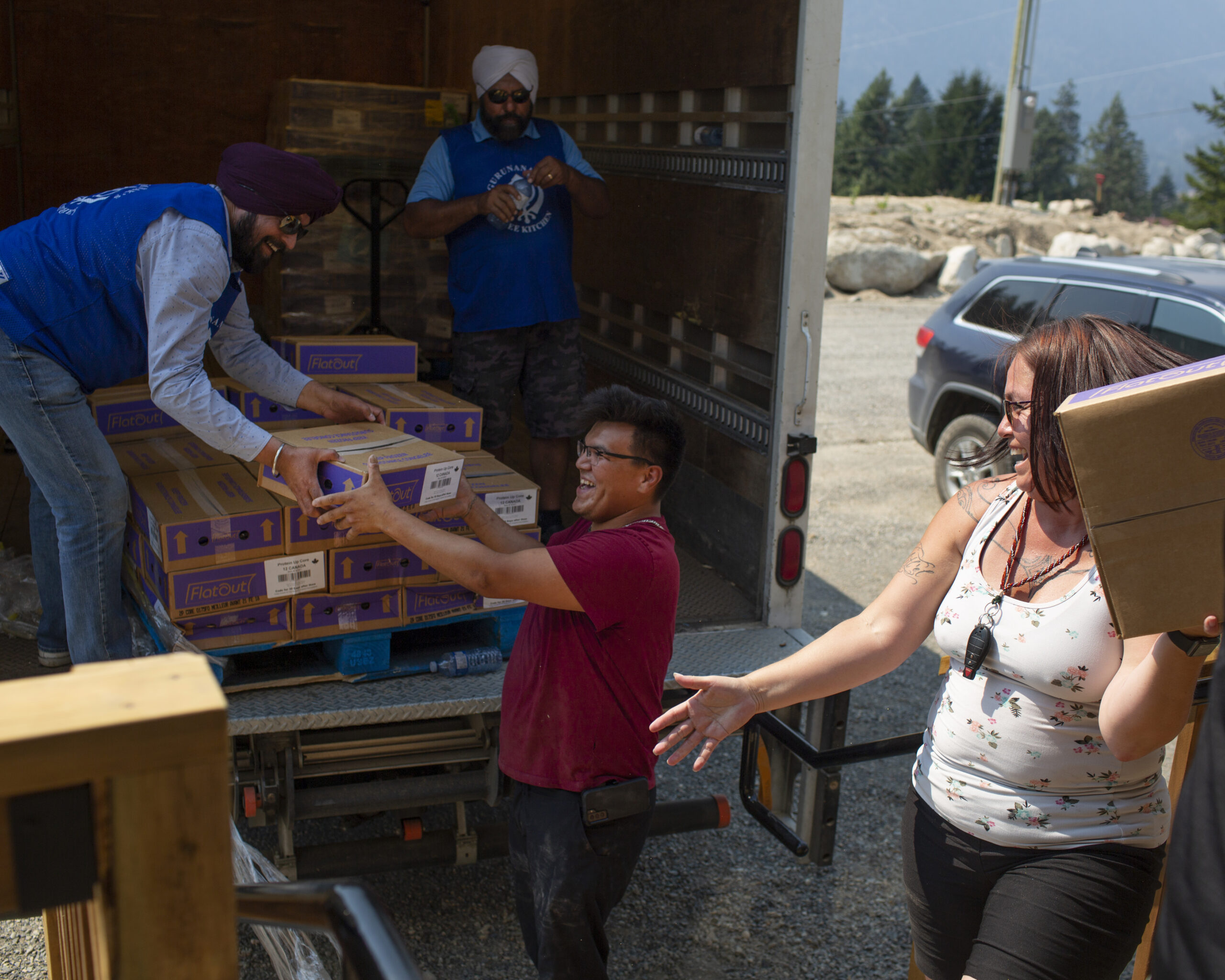 volunteers handing out food and water from a truck
