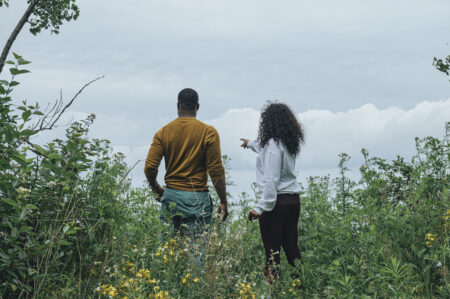 The backs of Greg Henderson and Shereen Ashman as they look out on water