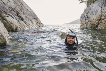 JennaMae Togado-Webb (she/her) swims in the ocean