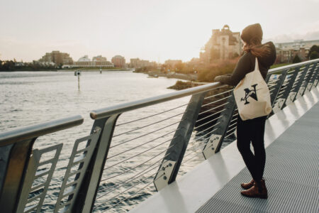 emma staring out at the water wearing a narwhal tote