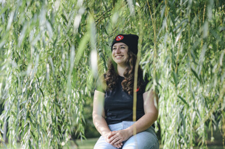 emma mcintosh posing outdoors by foliage
