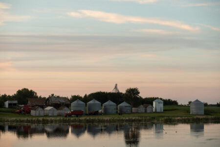 sunset on pond near oil and gas infrastructure