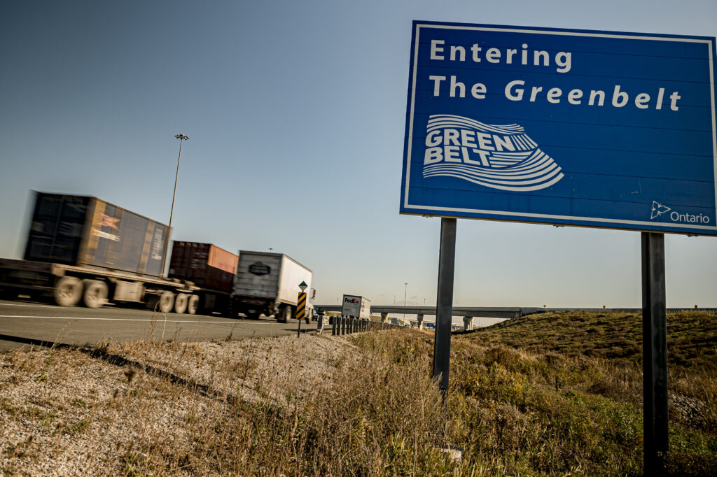 A photo of a highway sign that reads "Entering the Greenbelt"