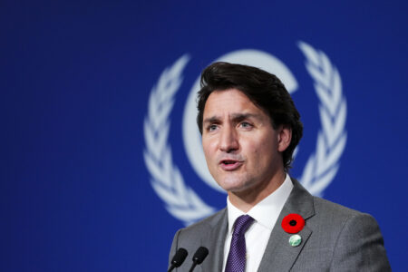 Canada's Prime Minister Justin Trudeau standing in front of a blue backdrop at the COP26 climate summit