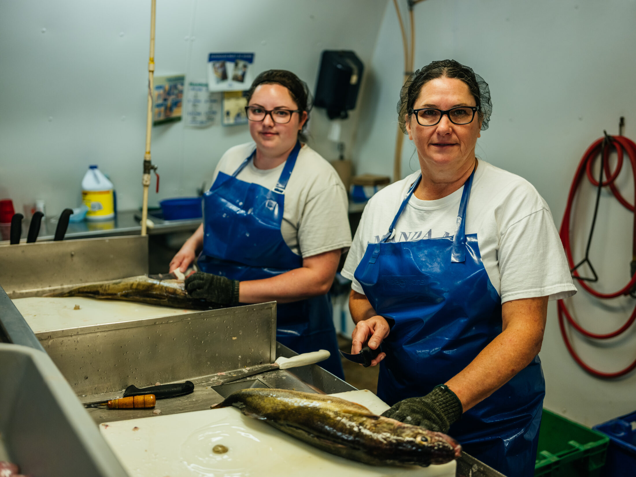 A photo of Brenda and Amanda Martin cleaning fish. 