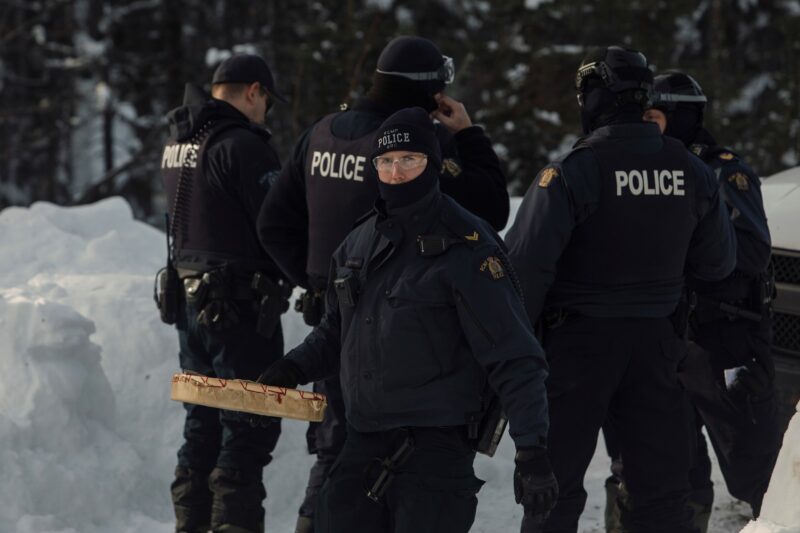 A police officer carries a drum after RCMP arrested Wet'suwet'en matriarchs in February 2020