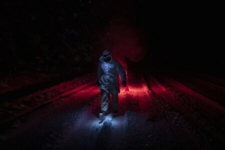 A person walks along the Morice Forest Service Road in the snow while enforcing an eviction order against Coastal GasLink