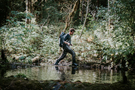A man walks along a river's edge