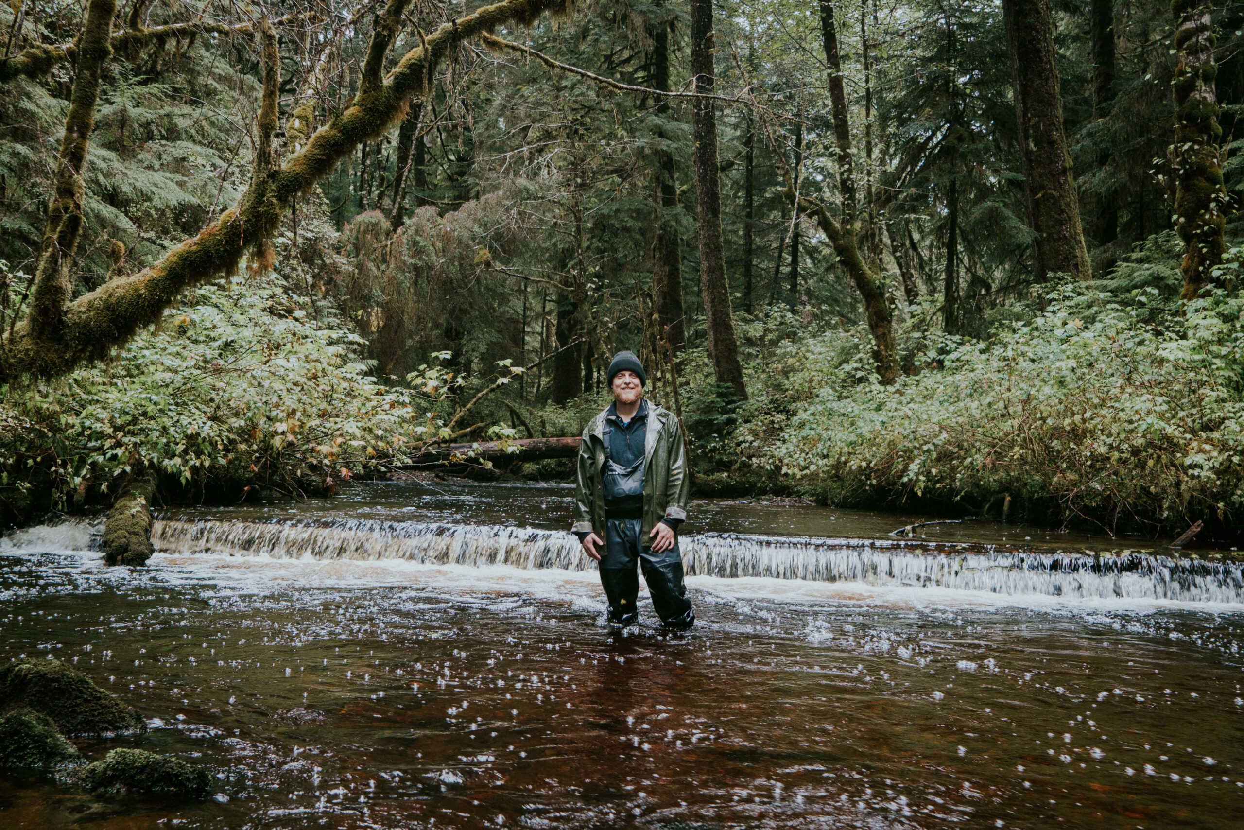 A man stands in waders in a river