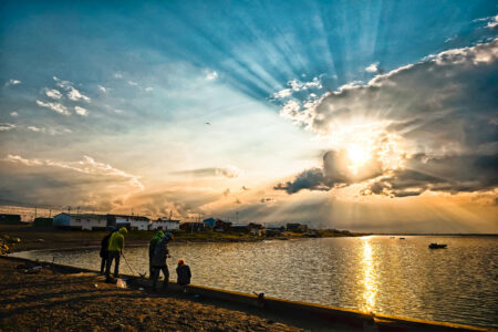 Boys fish at the shore of Arviat, Nunavut