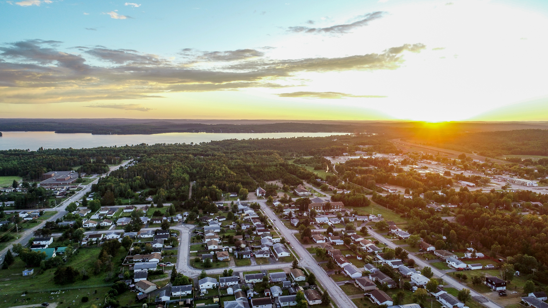 An aerial photo of the community of Ignace, with a golden sun on the horizon.