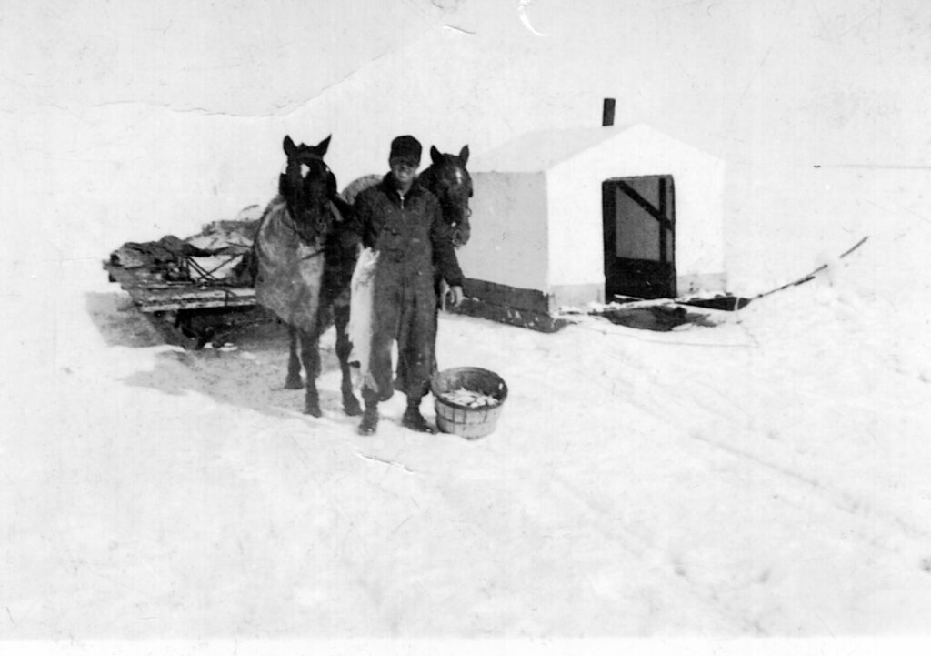 Wayne Weston from the Bay Mills Indian Community in Michigan and an unknown man ice fishing for herring, in the 1930s.