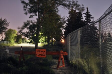 A "sidewalk closed" barrier is seen adjacent to a contaminated site in the Calgary area.