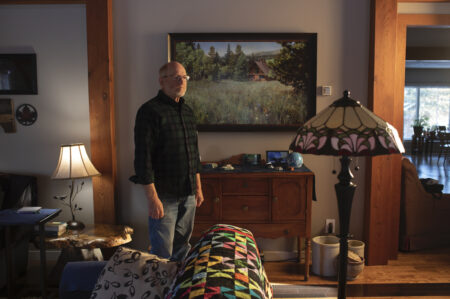 Arnold Janz stands in his living room.