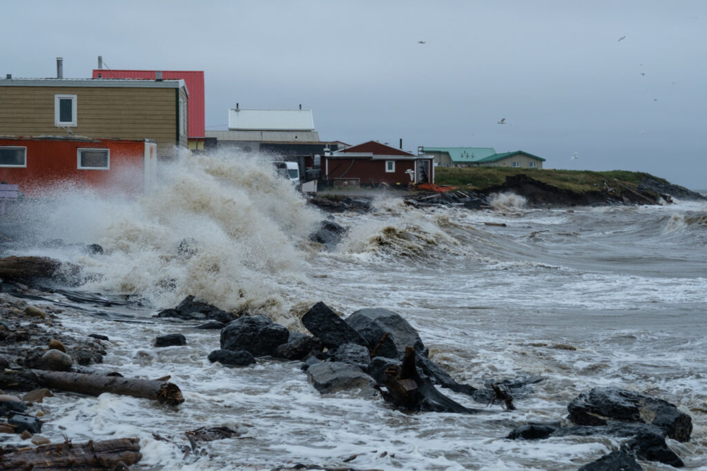 Waves crash on the shore near houses in Tuktoyaktuk