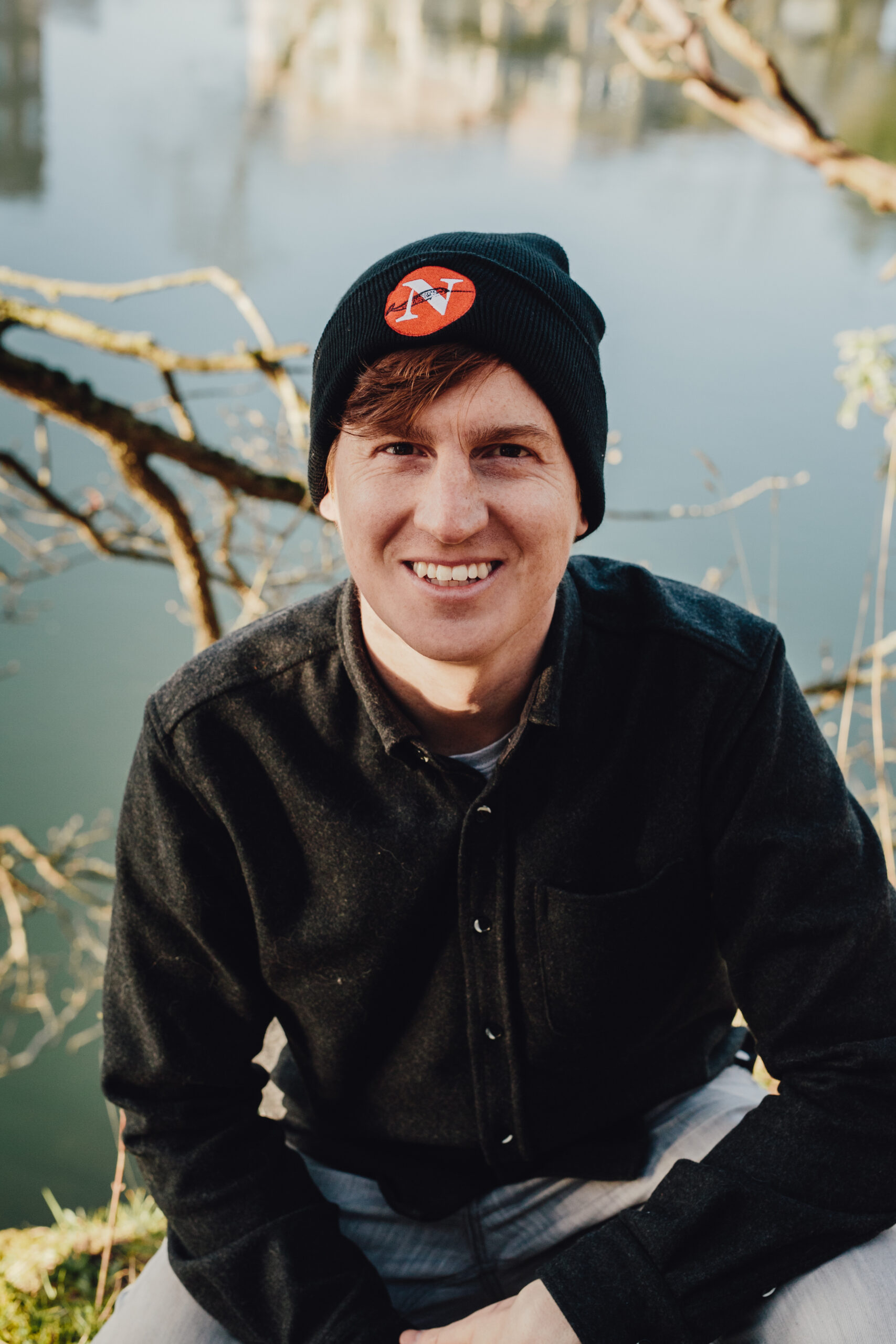 A photo of a man wearing a black toque with the red logo from The Narwhal