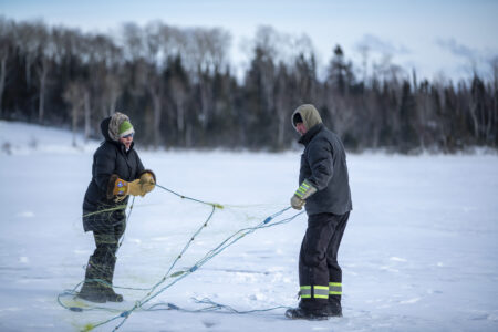 On Lake Superior, or Gitchigumi, Reporter Jolene Banning and Benny Solomon hold a fishing net