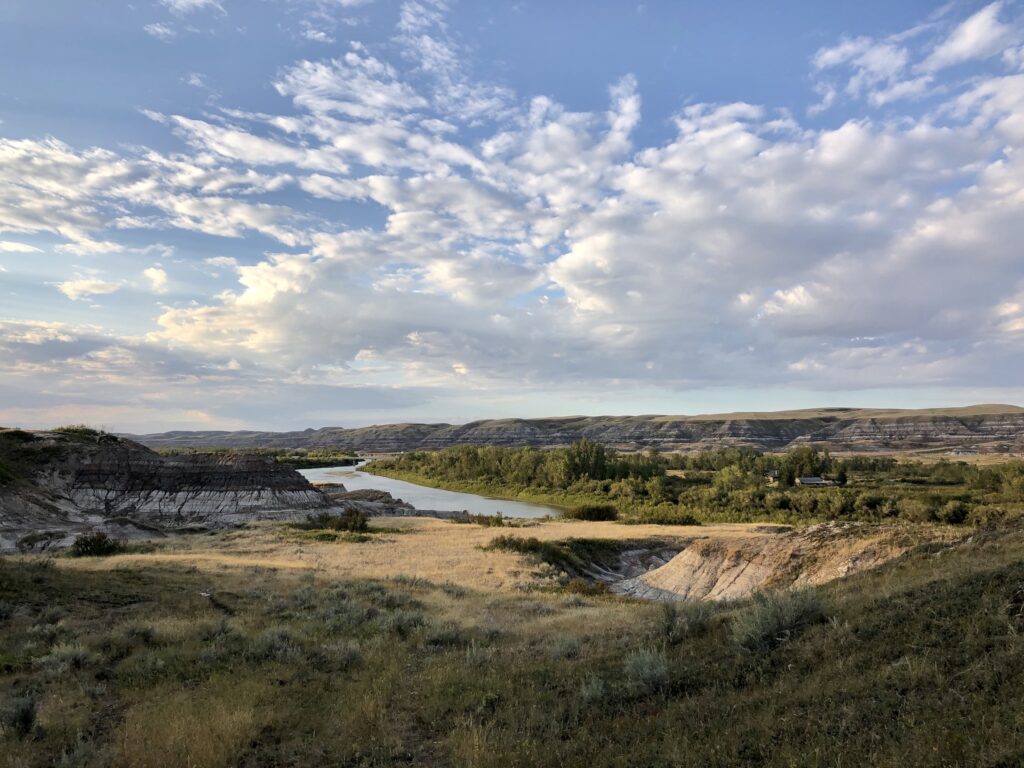The Red Deer River winds through a valley under blue skies