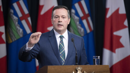 Alberta Premier Jason Kenney speaks from a podium.