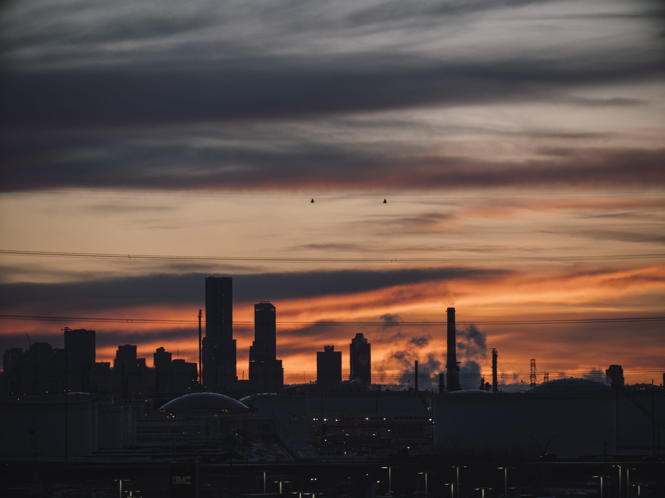 Refineries are silhouetted at sunset
