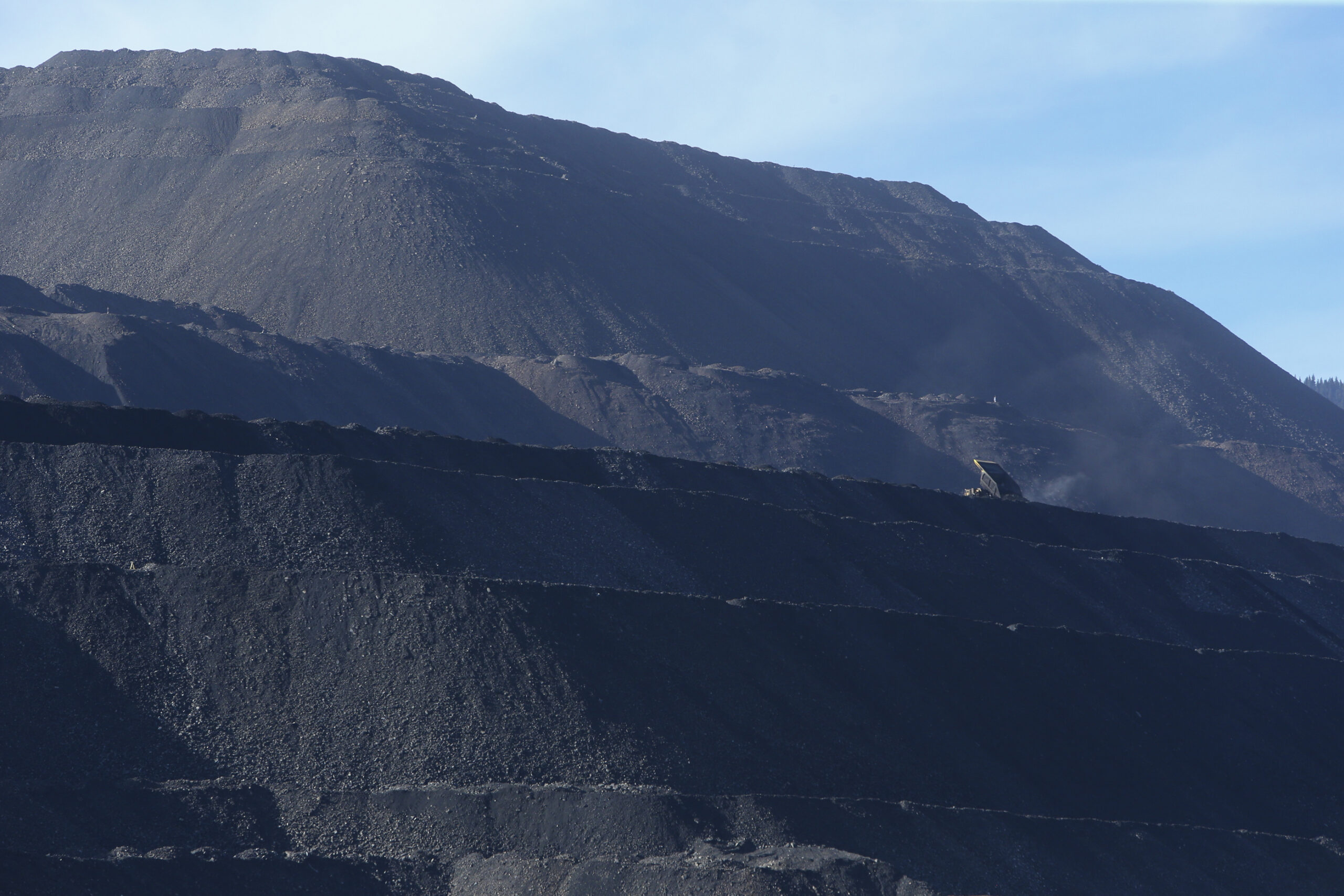 Terraced slopes of black waste rock at a Teck coal mine