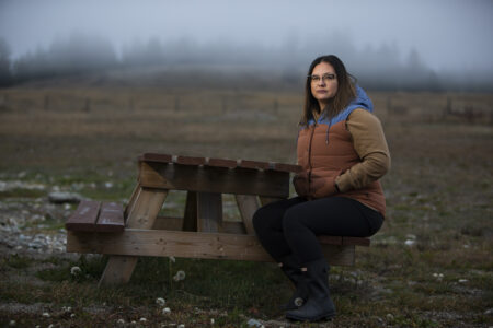 A woman sits at a picnic table