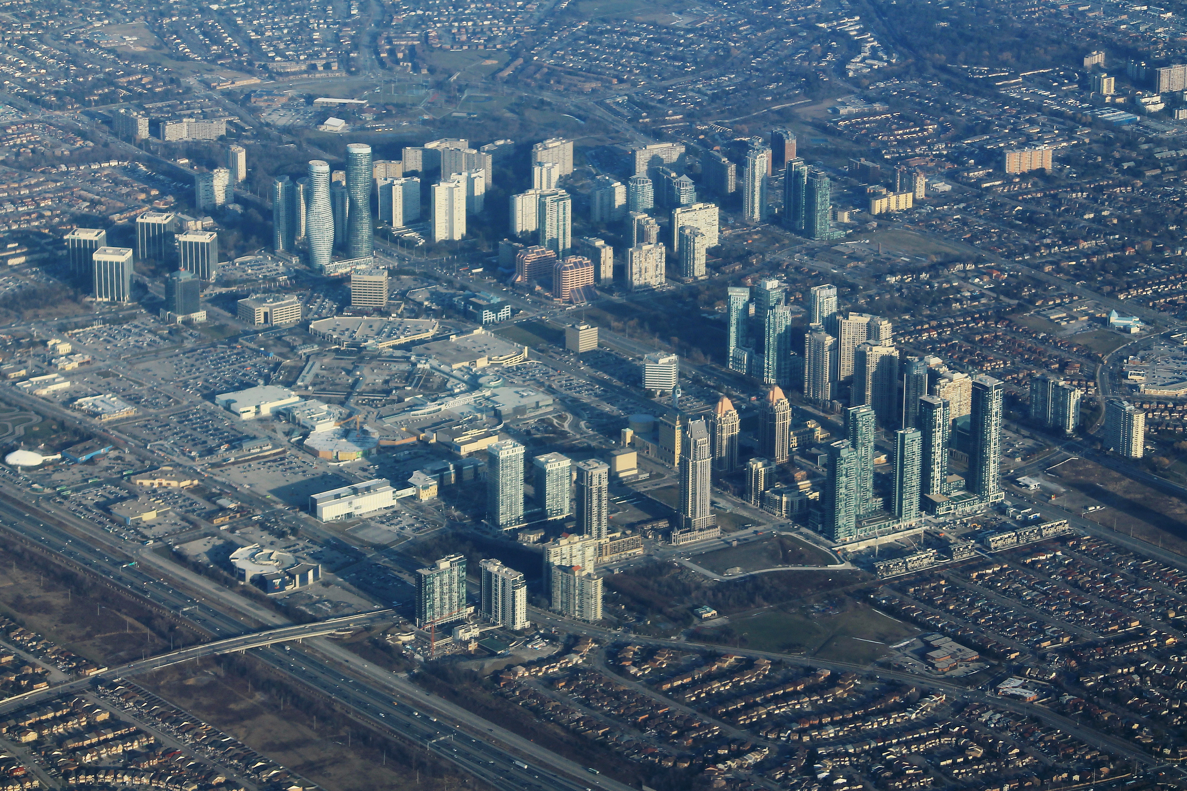 An aerial view of Mississauga's city centre, sleek high rises and the Square One mall, surrounded by sprawling suburban neighbourhoods.