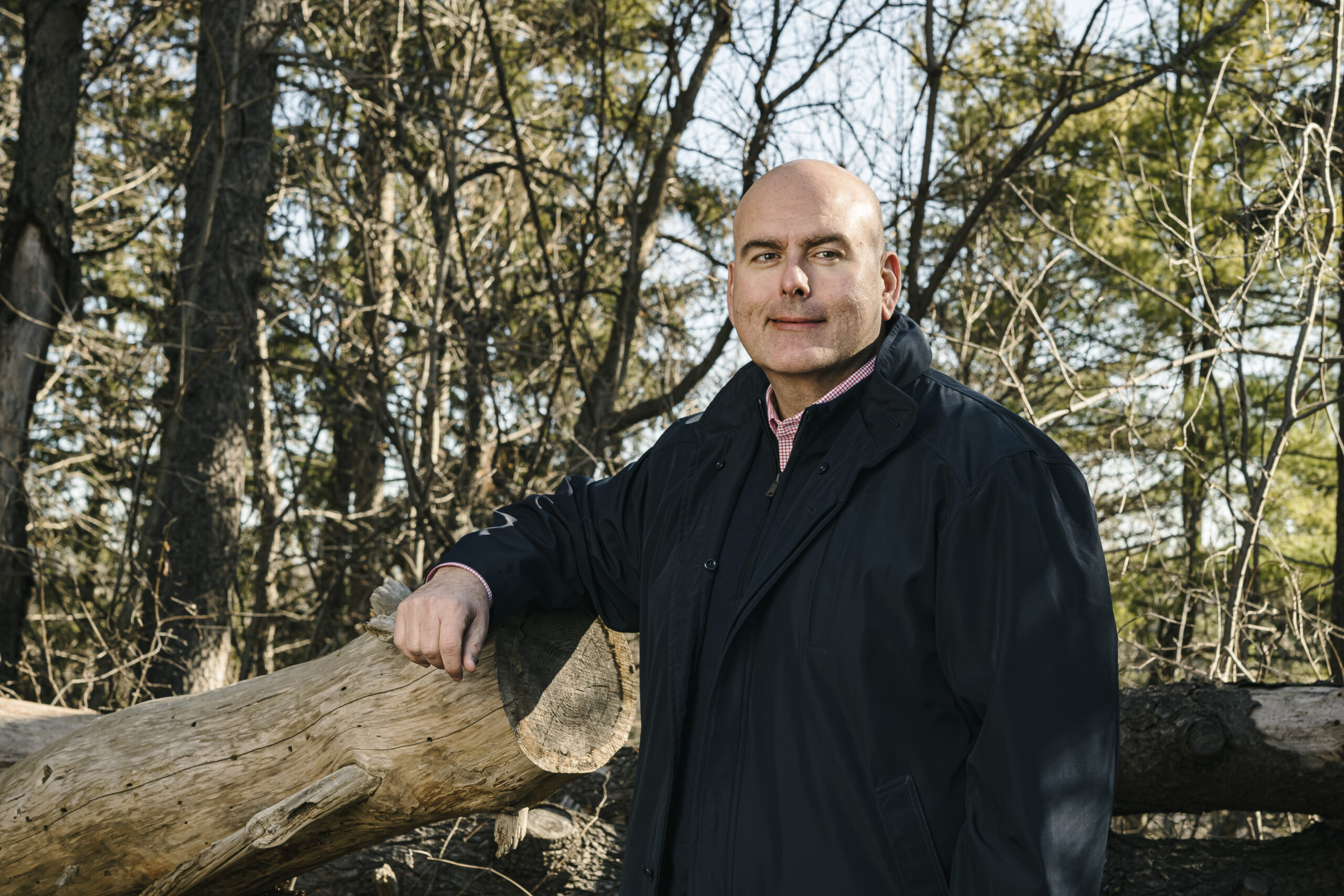 Ontario Liberal leader Steven Del Duca leans on a log in a bright forest with a slight smile, weeks before the launch of the 2022 Ontario election campaign.