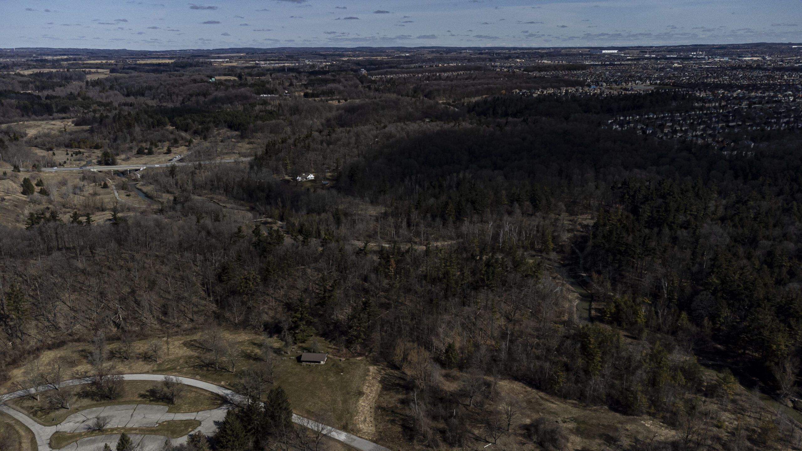 An aerial view of the Boyd Conservation Area with forest and trails in early spring, with suburbs on the horizon. Ontario Liberal leader Steven Del Duca often goes on walks in the area.