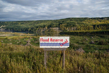 A sign reading 'flood reserve' level in red text shows how high floodwaters at the Site C dam will rise in the Peace River valley