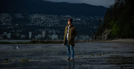 B.C. Biodiversity Reporter Ainslie Cruickshank poses for a photo at Third Beach in Stanley Park, on the unceded territories of the xʷməθkʷəy̓əm (Musqueam), Skwxwú7mesh (Squamish) and səl̓ilwətaɬ (Tsleil-Waututh) Nations.