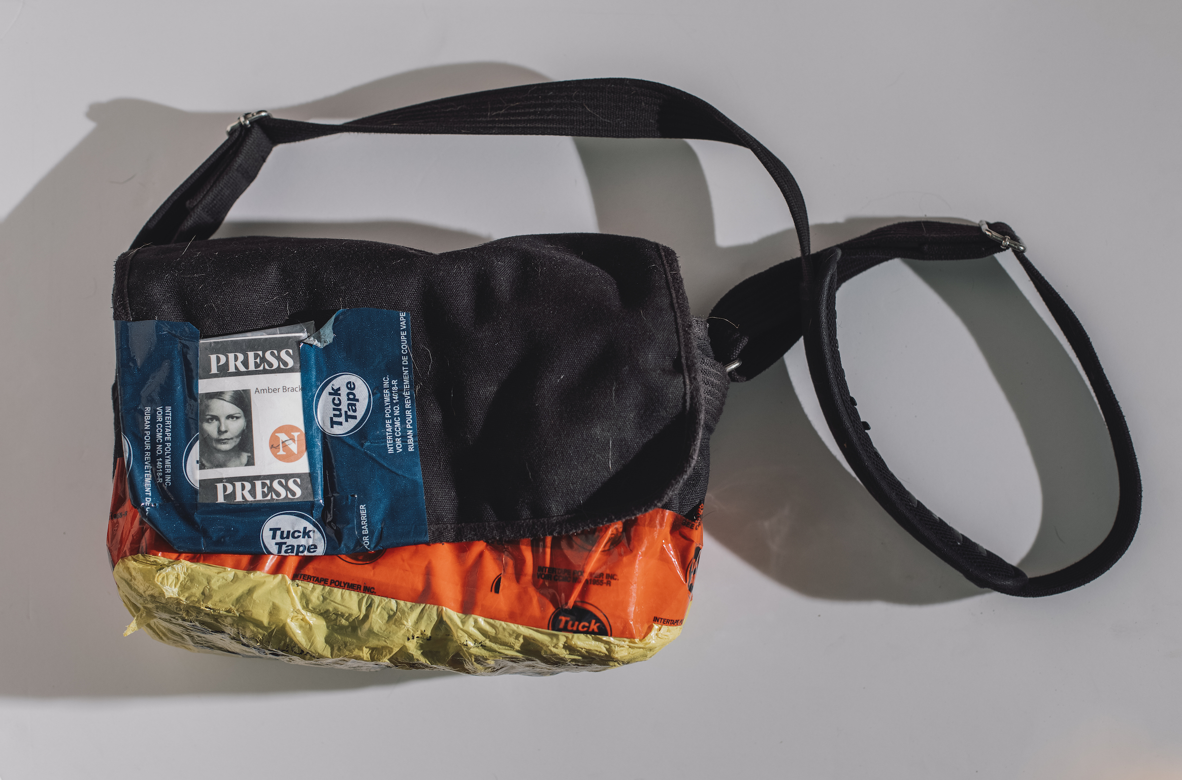 The camera bag used by photojournalist Amber Bracken when she was arrested while documenting the RCMP raid on Wet'suwet'en territory. A press credential label is seen taped on.