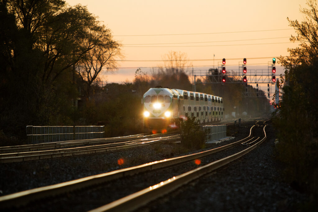 A GO train on tracks at sunset